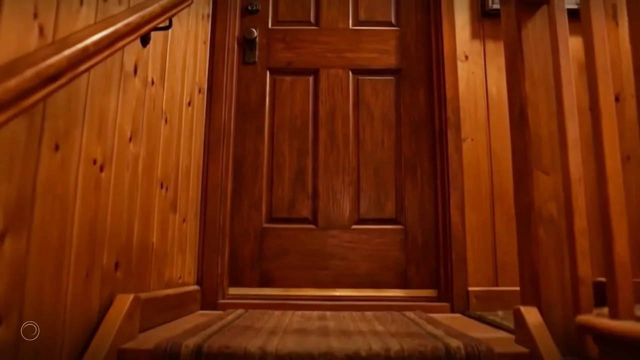 Staircase leading from the basement workshop to a wooden door