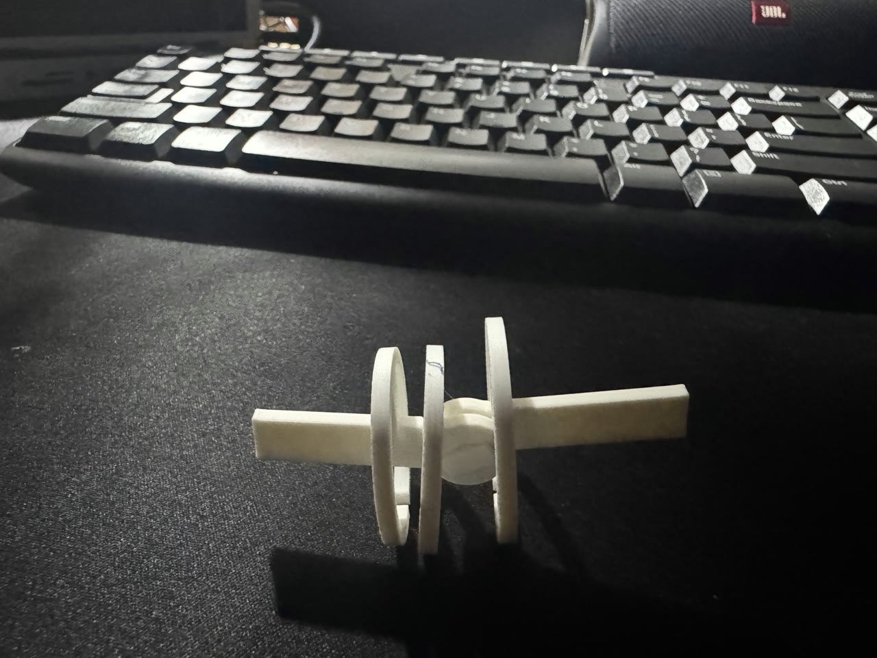 White printed hinge and collar test piece on a dark desk