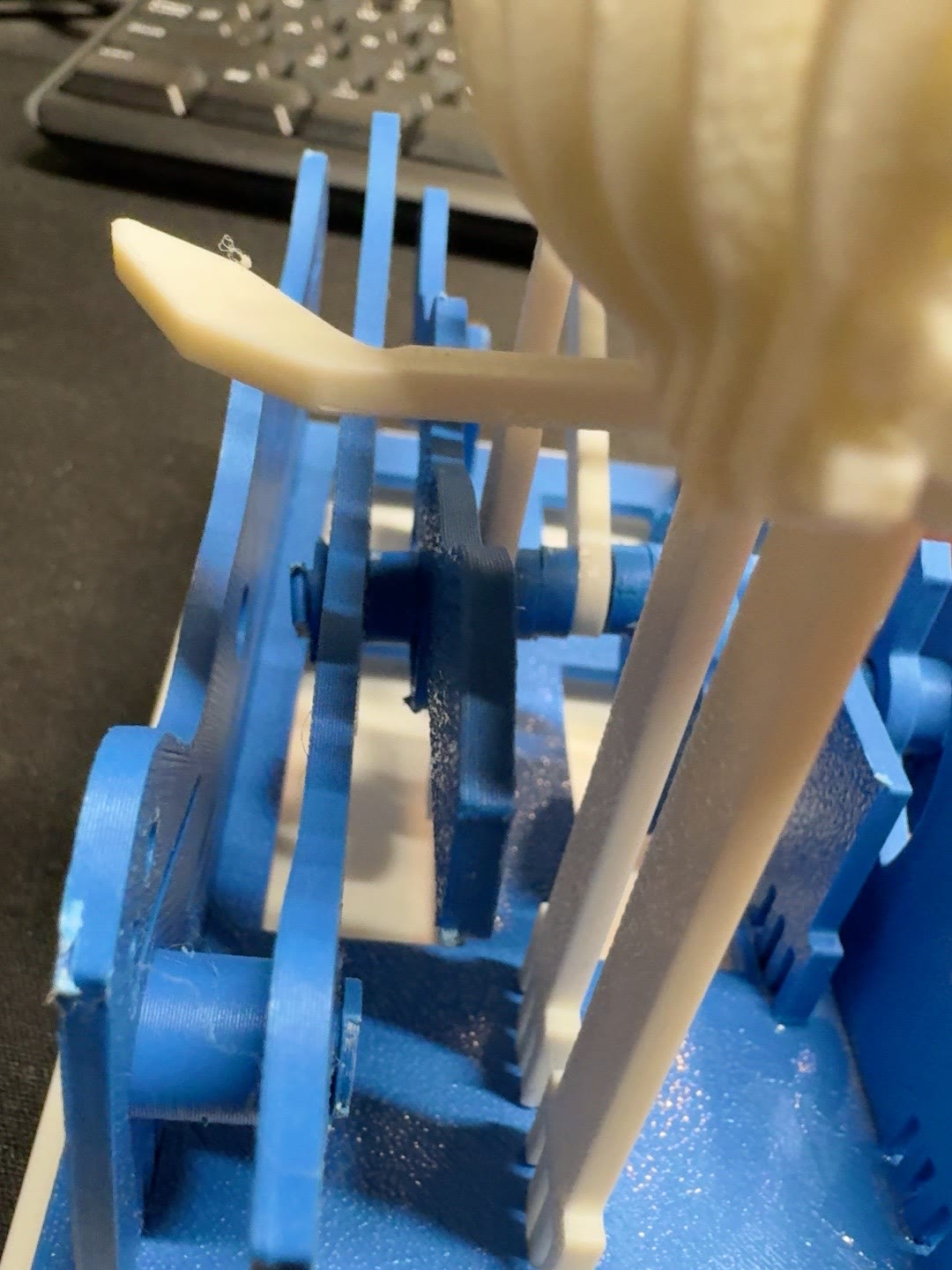 Close view of the blue moving wave panels and white linkage arranged along the whale drive shaft